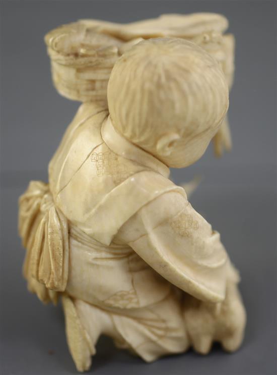 A Japanese ivory okimono of a boy with a dog, Meiji period, height 7.5cm excl. wood stand